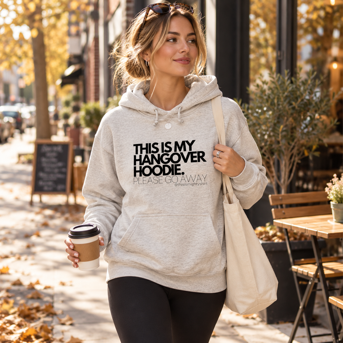 Woman wearing Ash This Is My Hangover Hoodie on an autumn café walk