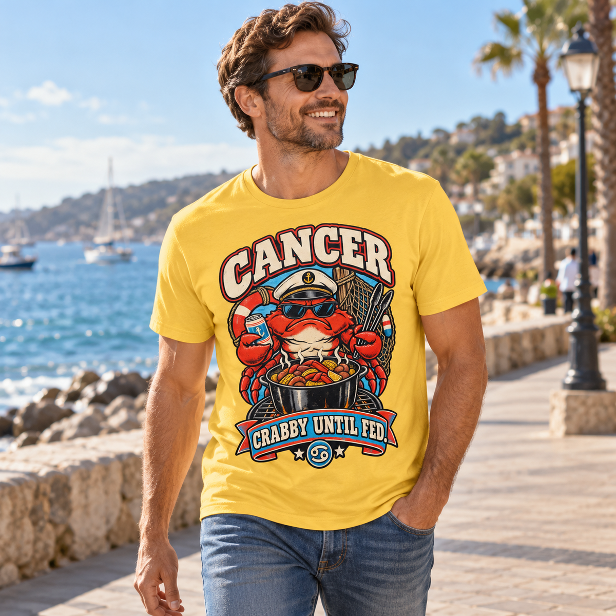 Cancer Crabby Until Fed Men's T-Shirt in Daisy, model walking on a seaside promenade with soft afternoon light