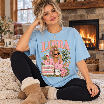 Libra Can't Decide Still Fabulous Women's T-Shirt – Light in Light Blue, model inside a cosy cottage seated beside a fireplace