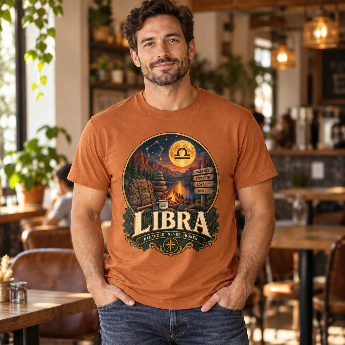 Libra Balanced Never Broken Men's T-Shirt in Fan Texas Orange, model indoors in a warm stylish cafe