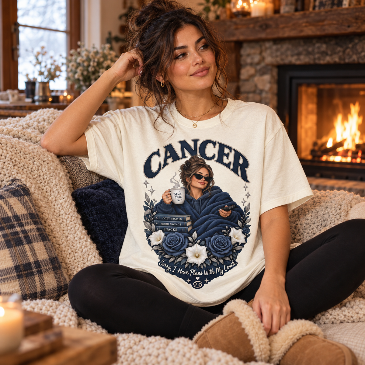 Cancer Plans with My Couch Women's T-Shirt – Dark in Off White, model seated cosily on a sofa beside a fireplace in a warm cottage