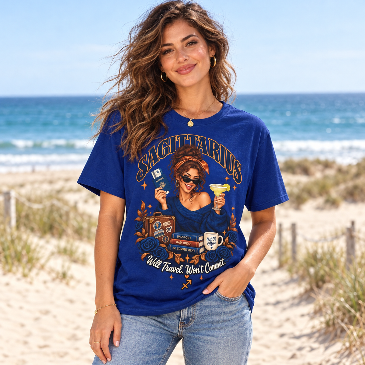 Sagittarius Will Travel Won't Commit Women's T-Shirt – Dark in Fan Deep Royal, model on a sandy beach with blue sea and dunes