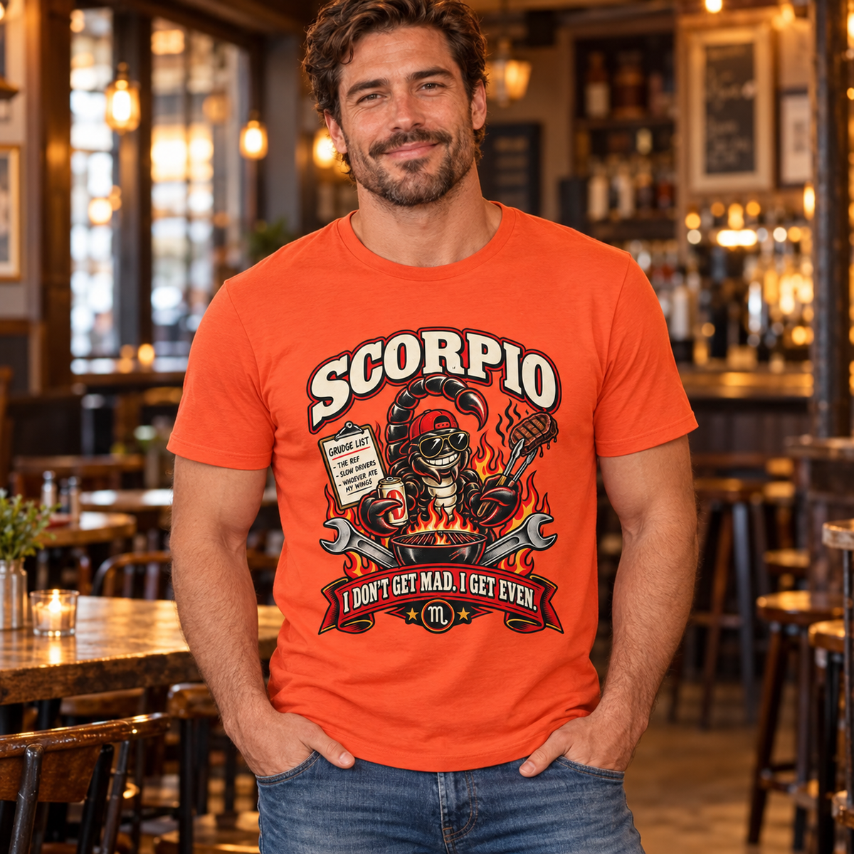 Scorpio I Don't Get Mad I Get Even Men's T-Shirt in Orange, model indoors in a warm contemporary pub with wooden tables