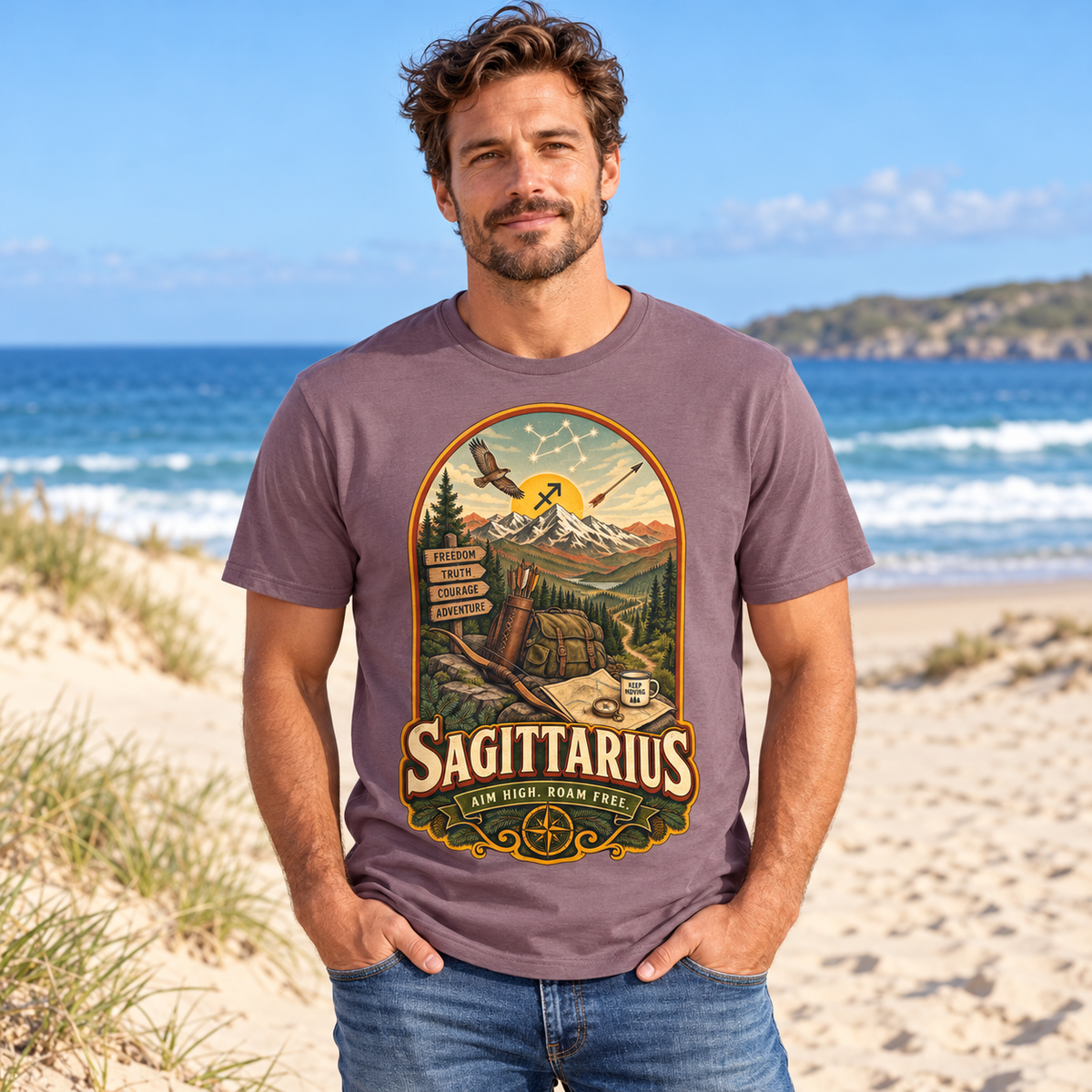 Sagittarius Aim High Roam Free Men's T-Shirt in Paragon, model on a sandy beach with blue sea and dunes