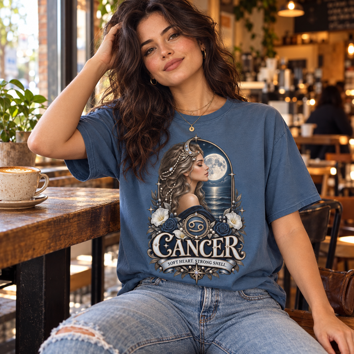Cancer Soft Heart Strong Shell Women's T-Shirt – Dark in Indigo, model inside a stylish warm coffee shop with window light