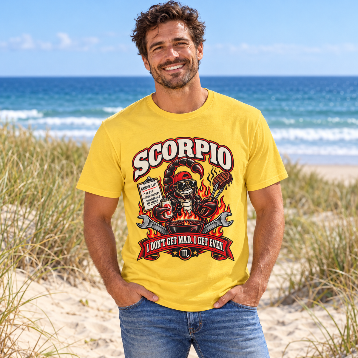 Scorpio I Don't Get Mad I Get Even Men's T-Shirt in Daisy, model at a sandy beach with dune grass and blue sea