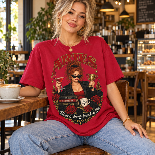 Aries Patience? Never Heard of Her Women's T-Shirt – Dark Colours, model wearing the original design in a cosy stylish coffee shop indoors.