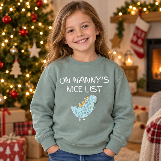 Child wearing Dusty Green On Nanny's Nice List dinosaur Christmas jumper